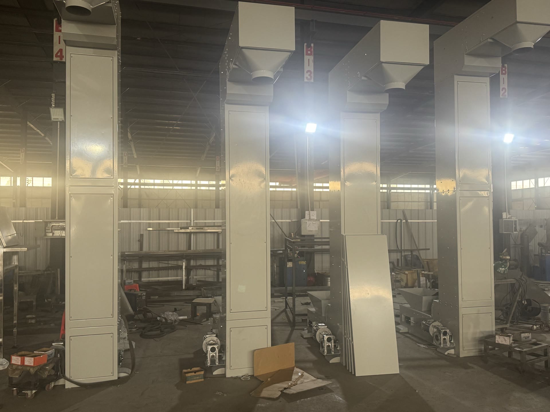 PENKOR bucket elevators — several enclosed vertical bucket-elevator units in the workshop