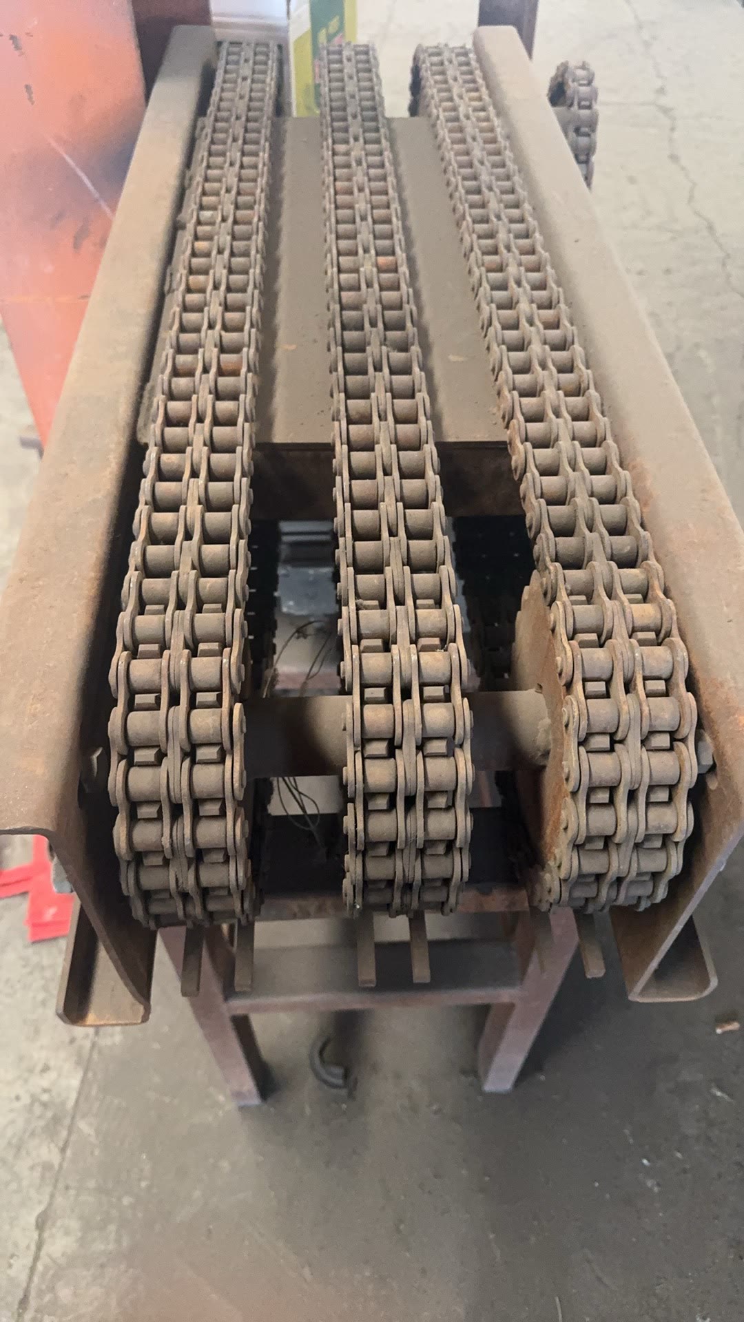PENKOR conveyor chains — multi-strand roller chains with attachment links on a conveyor frame, close-up