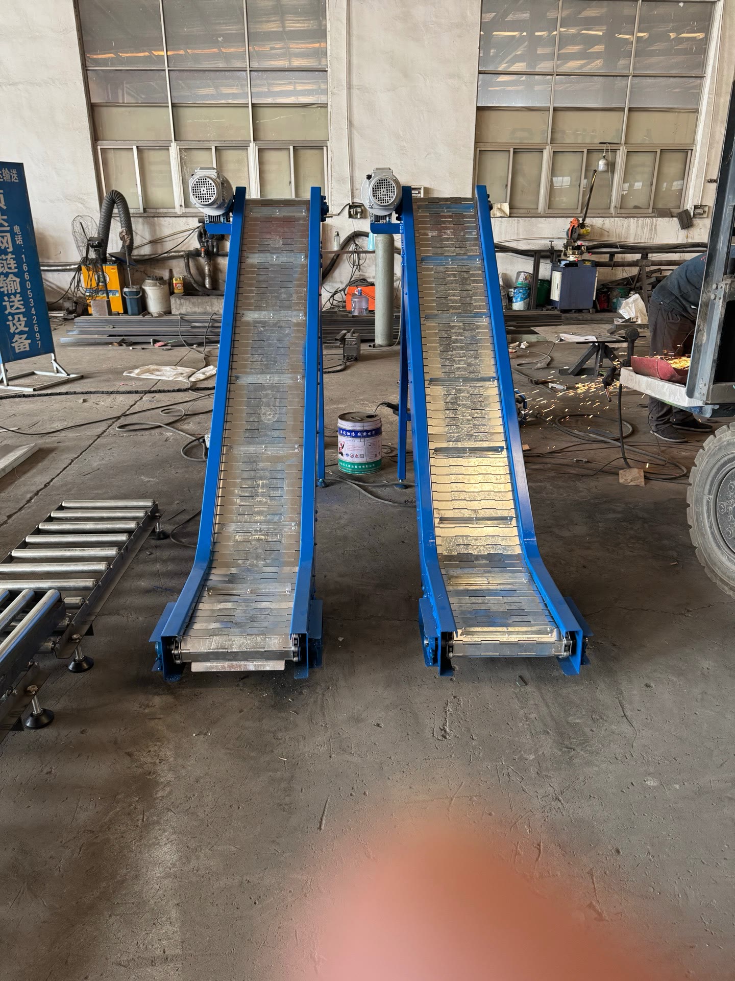 PENKOR inclined (slope) conveyors — two blue-framed inclined machines in the workshop