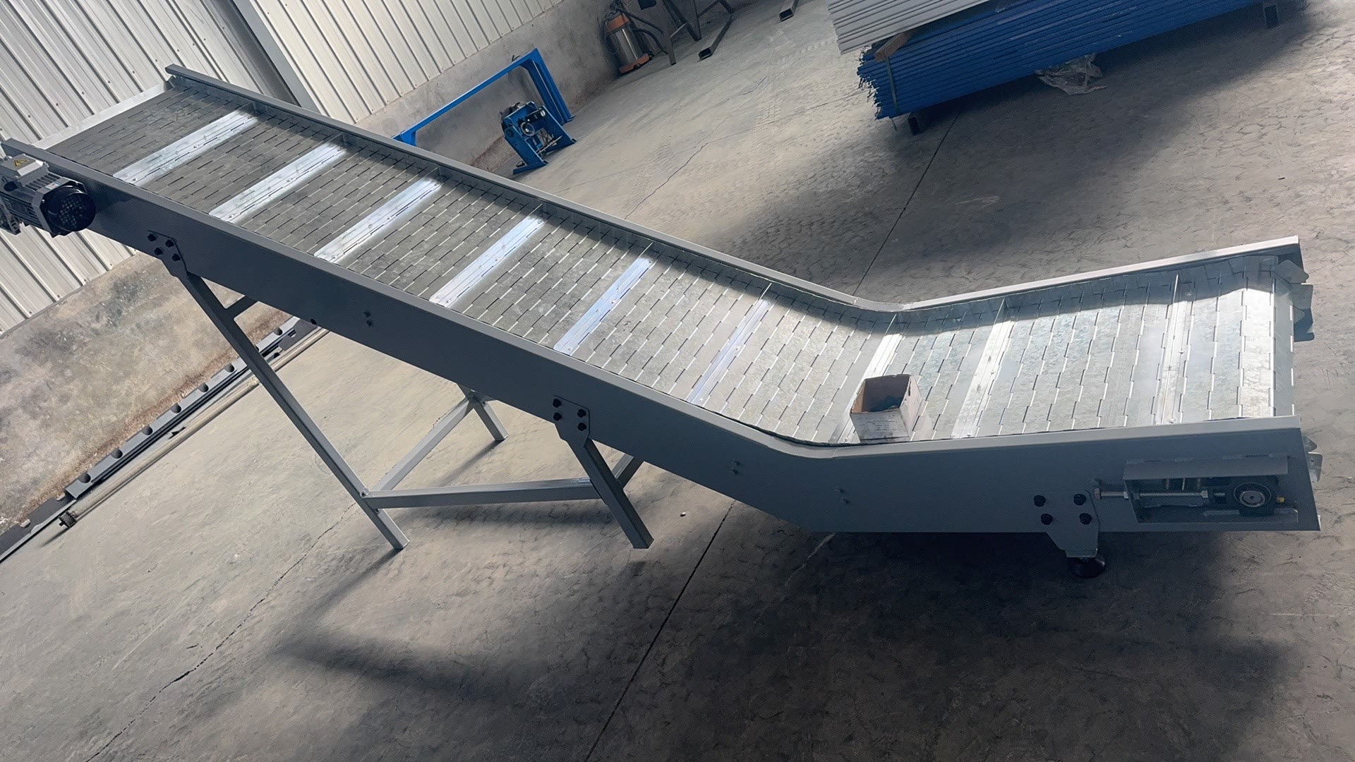 PENKOR inclined conveyor, another machine seen at an angle in the workshop