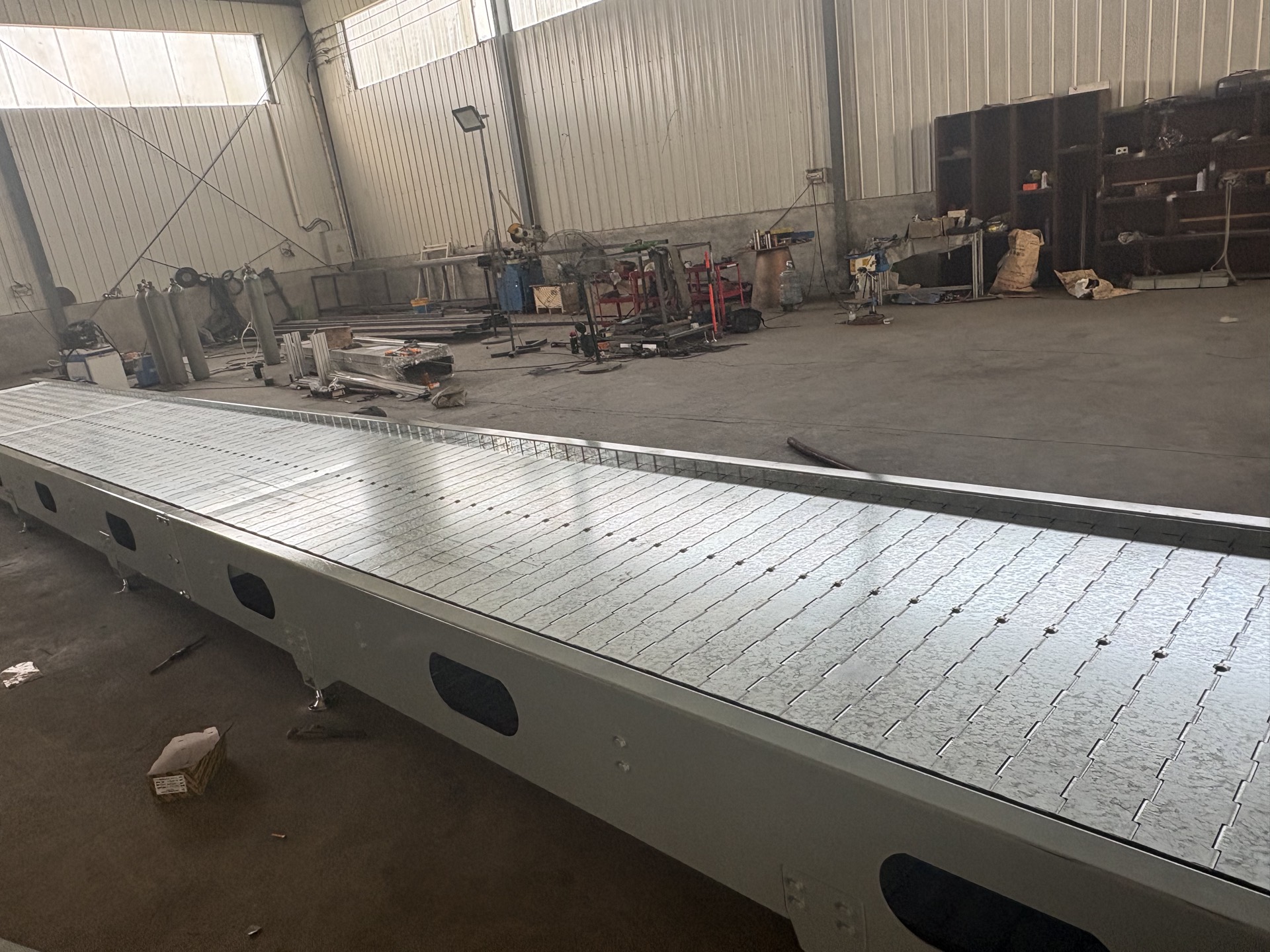 PENKOR slat chain conveyor, complete machine, side view in the workshop