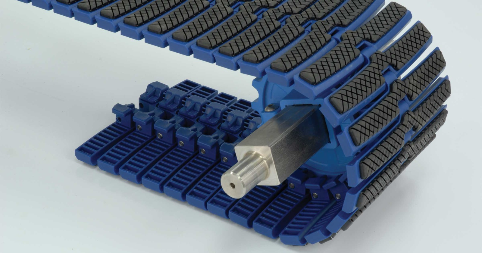 Plastic modular belt with rubber friction-top pads, wide-row interlocked modules, close-up (third-party reference photo)