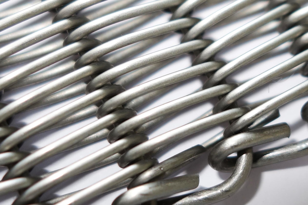 Macro of a stainless-steel woven (balanced) mesh belt surface (third-party reference photo)