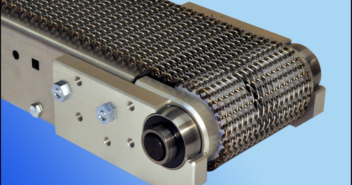Wire-mesh belt conveyor drive end — stainless mesh belt over the head pulley with bearing and frame (third-party reference photo)